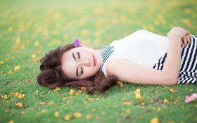 Sleeping girl in grass depicting the relaxing feeling of dental sedation