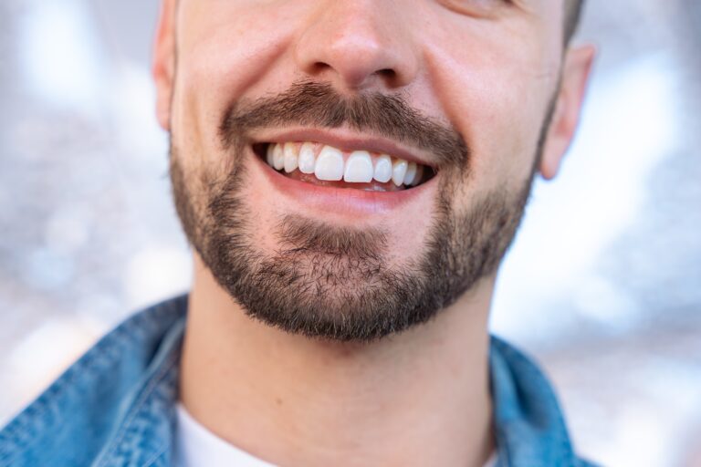 closeup of a man with a bear smiling, perfect white teeth