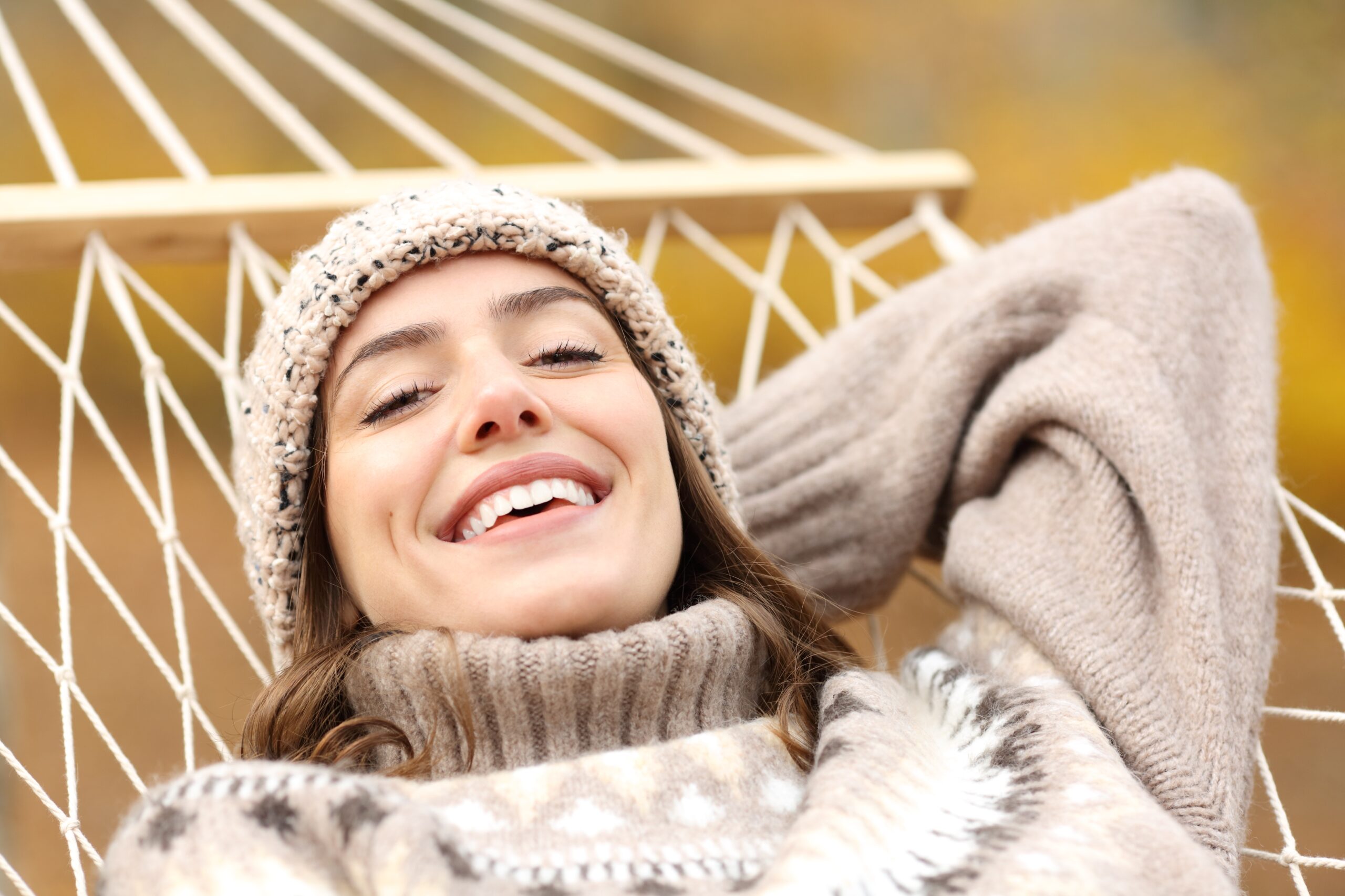 happy woman smiling on a hammock, perfect white teeth