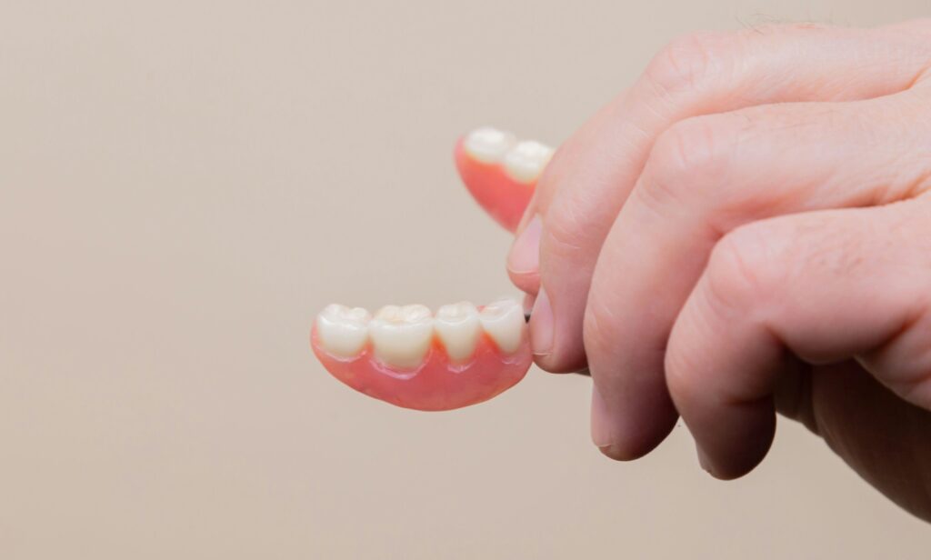 San Jose man holding traditional full dentures