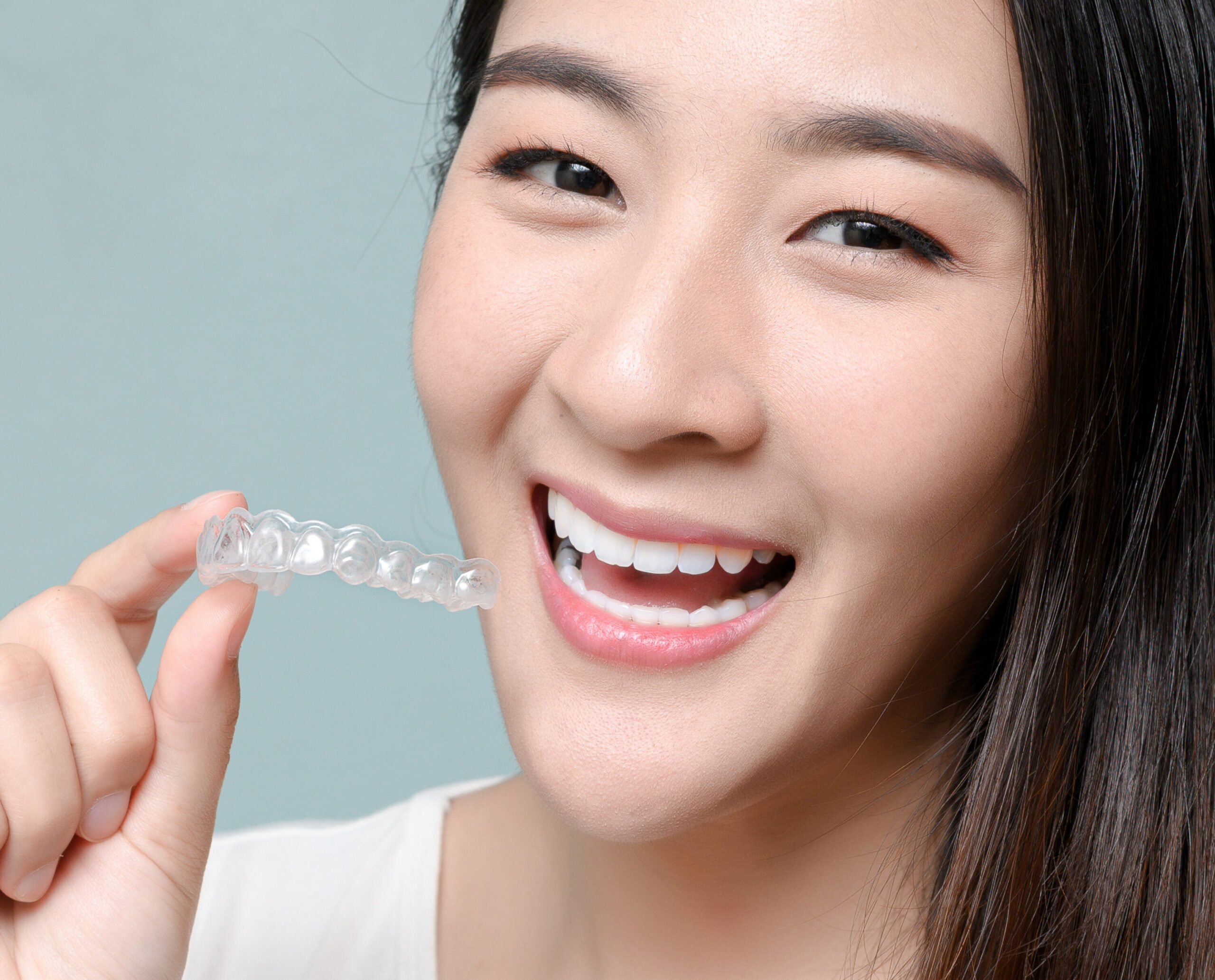 San Jose woman holding invisalign clear braces